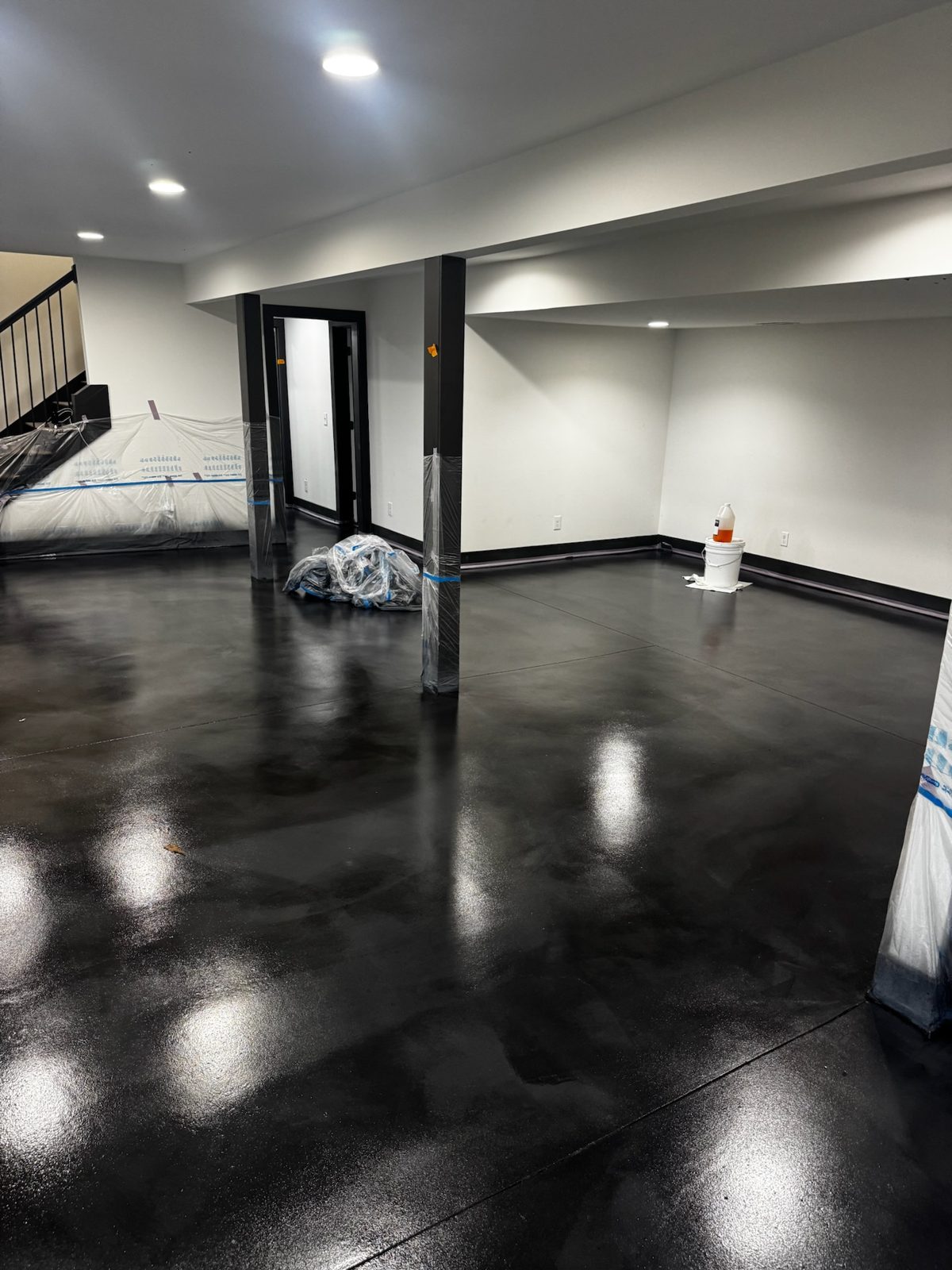 Aria sprayed microcement basement floor with custom stain — Forest Hills