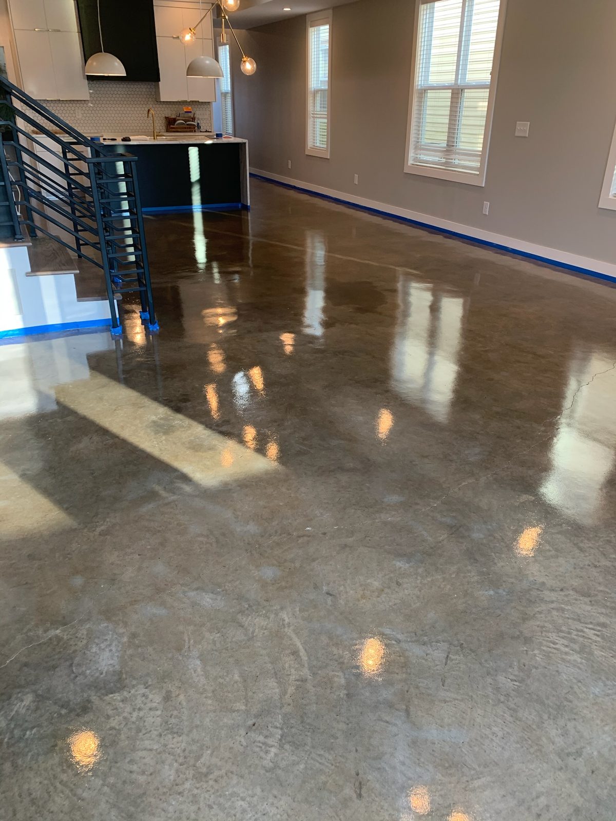 Patina custom-stained floor reflecting kitchen pendants — Nashville