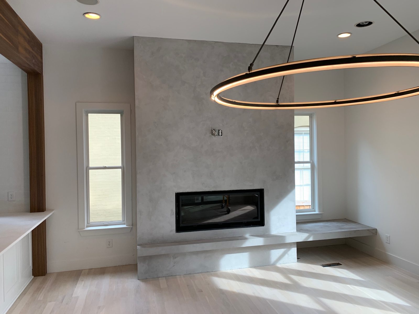 Velluto microcement fireplace wall with floating hearth bench — East Nashville