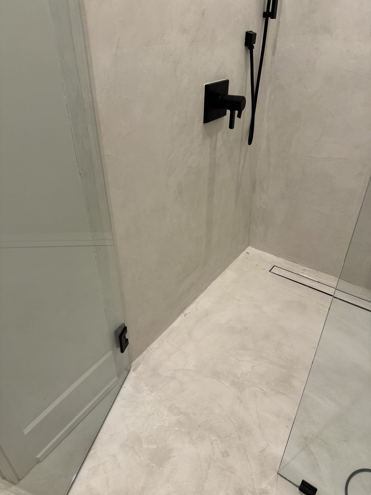 Velluto microcement shower walls and bench in the same West Meade primary bath, seen from the opposite corner